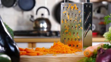 Izgarayı ve doğranmış havucu yavaş çekimde mutfak tahtasına yakın tut..