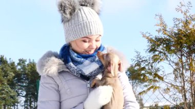 Genç bir kadın köpeğiyle oynuyor, pinscher ratter prazsky krysarik, kış havasında açık havada..