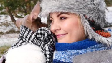 Köpeğiyle oynayan genç bir kadın, pinscher ratter prazsky krysarik, kış havasında dışarıda. Dişi köpek yavrusuna sevgiyle sarılıyor..