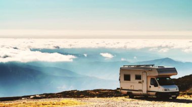 Karavan bulutların üstündeki dağlarda kamp yapıyor. Portekiz 'deki Serra da Estrela' nın Torre Dağı zirvesi. Ziyaret yeri. Gezici evde macera ve tatil.