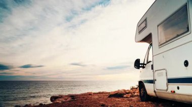 Deniz kenarında kamp yapan karavan aracının üzerinde hareket eden bulutların zamanı. Karavanla seyahat ediyorum. Karavan tatili. Doğa ve faaliyetler.