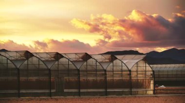 Akşamları, ticari seralarla birlikte kıyı manzarası üzerinde hareket eden bulutların hızlanması. Endüstriyel tarım. Murcia bölgesi, İspanya.