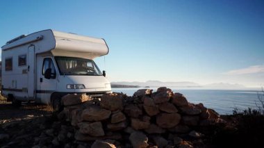 Kamp aracı deniz kenarında kamp yapıyor. Karavanla seyahat ediyorum. Karavan tatili. Doğa ve faaliyetler.