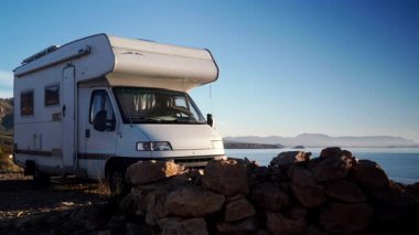 Kamp aracı deniz kenarında kamp yapıyor. Karavanla seyahat ediyorum. Karavan tatili. Doğa ve faaliyetler.