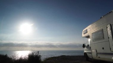 Bulutların sabah denizde hareket etmesi ve karavanın sahilde kamp kurması. Almerya Eyaleti, Endülüs İspanya. Karavanla seyahat ediyorum. Karavan tatili.