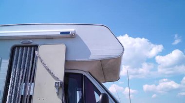 Karavanın üzerinde hareket eden beyaz bulutlar doğada kamp yapıyor. Karavanla seyahat ediyorum. Karavan tatili.