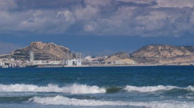 Alicante, valencia, İspanya - 5 Aralık 2019: Benacantil Dağı 'ndaki Santa Barbara Kalesi' nin uzak mesafesinden Akdeniz manzarası. İspanya, Costa Blanca. Deniz dalgaları ağır çekimde hareket ediyor.