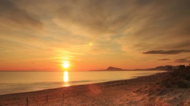 Sabahın erken saatlerinde denizde hareket eden bulutların hızlanması, güneşin doğması. Doğa manzarası. Gandia Sahili, Valencia İspanya.