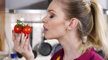 Küçük vişneli domates yiyen, sağlıklı yemek yiyen ve diyet yapan neşeli kadın..