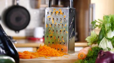 Izgarayı ve doğranmış havucu yavaş çekimde mutfak tahtasına yakın tut..