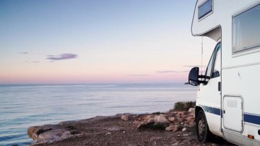 Kamp aracı deniz kenarında kamp yapıyor. Karavanla seyahat ediyorum. Karavan tatili. Doğa ve faaliyetler.