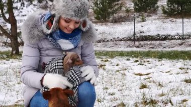 Genç bir kadın köpeğiyle oynuyor, pinscher ratter prazsky krysarik, kış havasında açık havada..