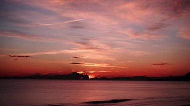 Sabahın erken saatlerinde denizde hareket eden bulutların hızlanması, güneşin doğması. Doğa manzarası. Gandia Sahili, Valencia İspanya.
