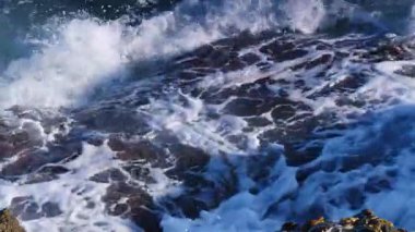 Büyük dalgalar kayalıklara çarpıyor. Ağır çekim. Yukarıdan görüntüle