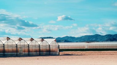 İspanya kıyılarında büyük ticari cam seralar ile hareket eden bulutların zaman akışı. Endüstriyel tarım. Murcia bölgesi, İspanya.