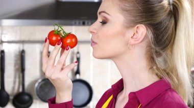 Küçük vişneli domates yiyen, sağlıklı yemek yiyen ve diyet yapan neşeli kadın..
