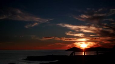 Deniz Burnu. Deniz kıyısında kırmızı turuncu renkli günbatımı. Doğa, kıyı manzarası. Zaman aşımı