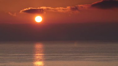 Sabahın erken saatlerinde deniz manzarası, deniz suyundan doğan güneş. Turuncu renkli gökyüzü. Doğa manzarası.