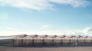 İspanya kıyılarında büyük ticari cam seralar ile hareket eden bulutların zaman akışı. Endüstriyel tarım. Murcia bölgesi, İspanya.