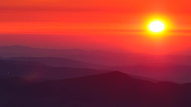 Bulutların üstündeki yüksek dağlarda yanan günbatımı. Portekiz 'de Serra da Estrela.