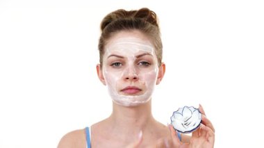 Maske takan genç bir kadın yüzüne nemlendirici krem sürüyor. Cilt nemlendiricisine dikkat eden bir kız. Cilt bakımı.