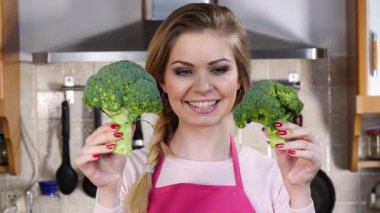 Ham yeşil sebze brokoli tutan mutlu genç kadın. Doğal organik sağlıklı gıda kavramı.