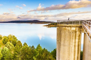 Palencia, Kastilya ve Leon 'daki Embalse de Aguilar de Campoo Gölü' nün oradan seyahat fotoğrafları çeken tripodlu profesyonel kamera..