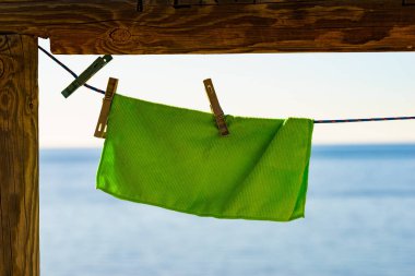 Kumsalda kamp yapmak, macera konsepti. Çamaşır bezi kuruması için sahildeki çamaşır ipine asılmış mavi deniz suyuna karşı..