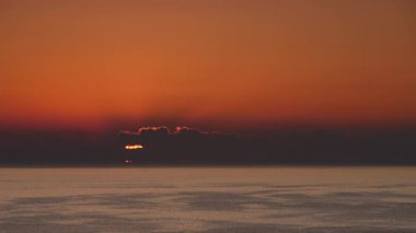 Sabahın erken saatlerinde deniz manzarası, deniz suyundan doğan güneş. Turuncu renkli gökyüzü. Doğa manzarası.
