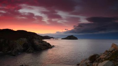 Gün batımında deniz manzarası. Akdeniz ve kayalık kıyı akşamları. Galiçya İspanya 'da Cabo de Moras manzarası.