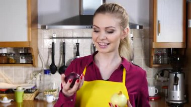 Kırmızı ve beyaz soğan tutan mutlu kadın yavaş çekimde aralarında seçim yapıyor. Sağlıklı beslenme, gıda kararları kavramı.