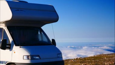 Karavan bulutların üstündeki dağlarda kamp yapıyor. Portekiz, Serra da Estrela 'nın Torre Dağı zirvesi. Ziyaret yeri. Macera ve gezici ev tatili. Zaman Uygulaması