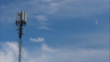 Telekomünikasyon kulesinin üzerinde 4G veya 5G hücresel ağ anteniyle hareket eden bulutların zaman akışı. Yeni mobil yayın teknolojisi üretimi.