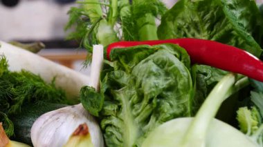 Mutfak masasında yavaş çekimde yakalanan çeşitli sağlıklı sebzeleri kapatın. Doğal beslenme konsepti..