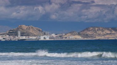 Alicante, valencia, İspanya - 5 Aralık 2019: Benacantil Dağı 'ndaki Santa Barbara Kalesi' nin uzak mesafesinden Akdeniz kıyısı. İspanya, Costa Blanca. Deniz dalgaları ağır çekimde.