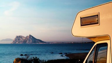 Sabah kumsalda karavan kampı, Punta Mala, Endülüs İspanya. Ufukta Cebelitarık kayası, İspanya kıyılarında İngiliz denizaşırı toprakları.