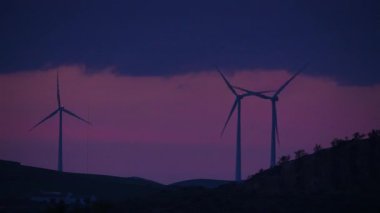 Alacakaranlıkta tepelerde rüzgar türbinleri. Ardales, Malaga ili, Endülüs İspanya yakınlarındaki yenilenebilir enerji üretimi için enerji jeneratörü çiftliği.