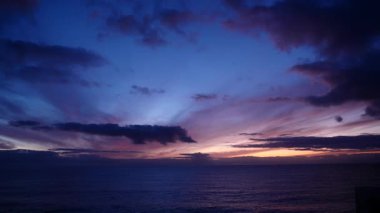 Sabahın erken saatlerinde deniz manzarası. Deniz üzerindeki kara bulutlar, şafak söküyor. İspanya 'daki doğa manzarası.