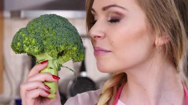 Ham yeşil sebze brokoli tutan mutlu genç kadın. Doğal organik sağlıklı gıda kavramı.
