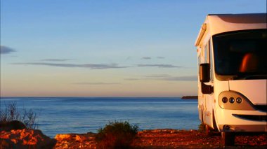 Kamp karavanı deniz kenarında, sabah vakti. Karavanla seyahat ediyorum. Karavan tatili. Doğa ve aktiviteler. Zaman Uygulaması