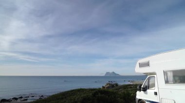 Sabah kumsalda karavan kampı, Punta Mala, Endülüs İspanya. Ufukta Cebelitarık kayası, İspanya sahillerinde İngiliz denizaşırı toprakları. Zaman aşımı