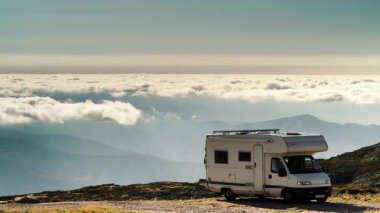 Karavan bulutların üstündeki dağlarda kamp yapıyor. Portekiz, Serra da Estrela 'nın Torre Dağı zirvesi. Ziyaret yeri. Macera ve gezici ev tatili. Zaman Uygulaması