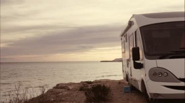 Bulutların entegre karavan üzerinde hareket etmesi deniz kenarında kamp kurması, bulutlu yağmurlu hava. Karavanla seyahat ediyorum. Karavan tatili. Doğa ve faaliyetler.