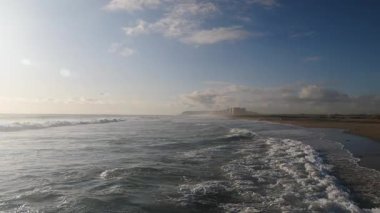 Kumsal kıyısı. Deniz dalgaları yavaş çekimde sıçrıyor.