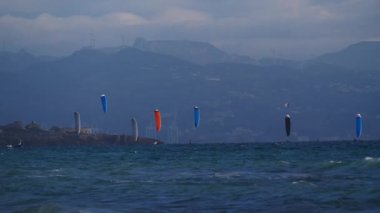Uçurtma kaykayı. Birçok uçurtma sörfçüsü dalgalarda sörf yapar, tarifa İspanya. Spor aktivitesi. Uçurtma yarışı. Yavaş çekim
