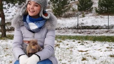 Genç bir kadın köpeğiyle oynuyor, pinscher ratter prazsky krysarik, kış havasında açık havada..