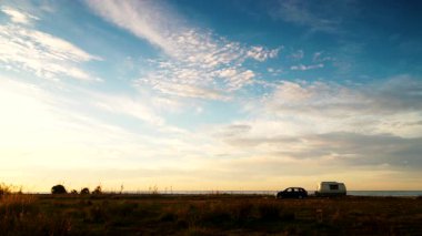 Deniz kıyısında kamp yapan karavan karavanıyla birlikte kıyı arazisinde bulutların hızlanması. Capicorb, Valencia bölgesi İspanya. Gezici evle tatil.