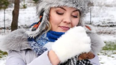 Köpeğiyle oynayan genç bir kadın, pinscher ratter prazsky krysarik, kış havasında dışarıda. Dişi köpek yavrusuna sevgiyle sarılıyor..