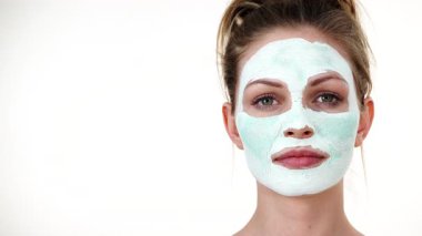 Yüzünde beyaz yeşil çamur maskesi olan genç bir kadın. Genç kız yağlı cildiyle ilgileniyor, gözenekleri temizliyor. Güzellik tedavisi. Cilt bakımı.