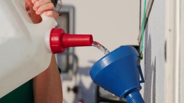 Karavan su deposunu huni kullanarak dolduran bir kadına yaklaş. Karavanla seyahat ediyorum. Karavan tatili. Yavaş çekim